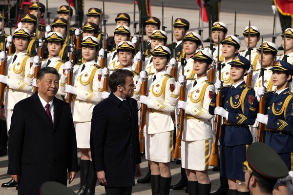 Президент Китая Си Цзиньпин (слева) и его французский коллега Эммануэль Макрон осматривают почетный караул во время официальной церемонии встречи в Пекине 6 апреля 2023 года. - Sputnik Молдова