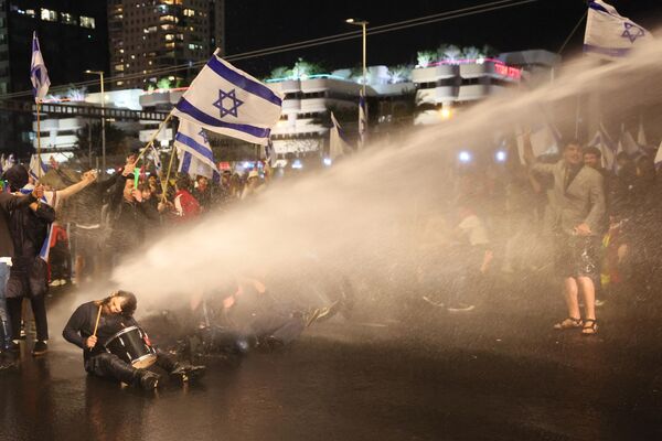 Израильская полиция поливает водой протестующих во время митинга против правительственного законопроекта о судебной реформе в Тель-Авиве 1 апреля 2023 года. - Sputnik Молдова