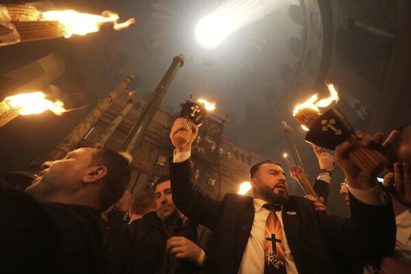 Pelerinii creștini țin lumânări în timpul ceremoniei Focului Sfânt, cu o zi înainte de Paște, la Biserica Sfântului Mormânt - Sputnik Moldova