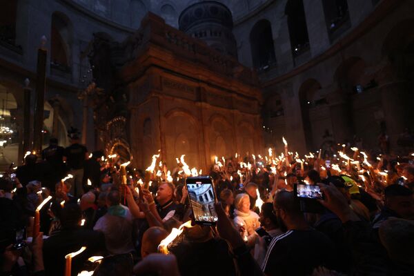 Православные христиане с зажженными свечами вокруг Кувуклии, считающейся местом захоронения Иисуса Христа. - Sputnik Молдова