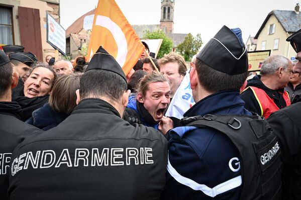 Жандармы оттесняют демонстрантов во время акции протеста против визита президента Франции Эммануэля Макрона в Муттершольц на востоке Франции. - Sputnik Молдова