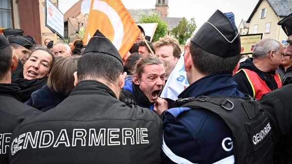 Жандармы оттесняют демонстрантов во время акции протеста против визита президента Франции Эммануэля Макрона в Муттершольц, восточная Франция - Sputnik Moldova