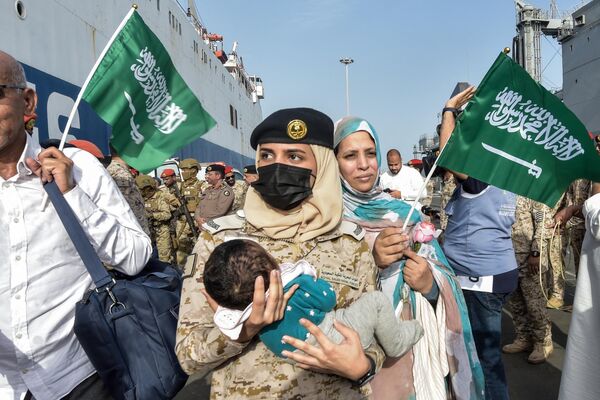 Военнослужащая ВМС Саудовской Аравии несет ребенка после успешной эвакуации 1687 граждан Саудовской Аравии из Судана на военно-морской базе короля Фейсала в Джидде. - Sputnik Молдова