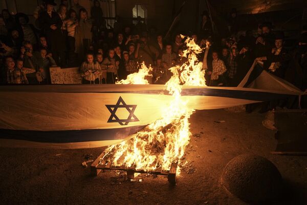 Ультраортодоксальные евреи сжигают израильский флаг в день 75-летия основания государства в районе Меа Шеарим в Иерусалиме. - Sputnik Молдова