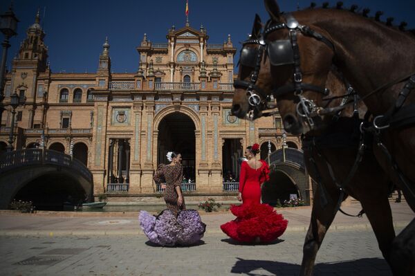 Женщины в традиционных андалузских платьях танцуют на площади в Севилье, Испания. - Sputnik Молдова