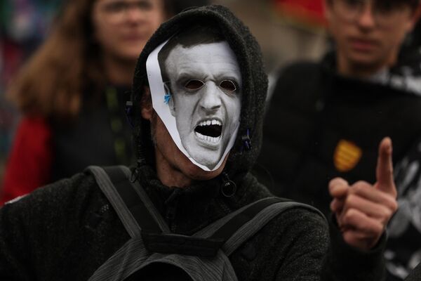 Протестующий в маске, изображающей президента Франции Макрона, принимает участие в первомайской демонстрации в Бордо. - Sputnik Молдова