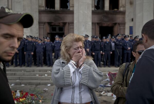 Женщина плачет у сгоревшего Дома профсоюзов в Одессе. - Sputnik Молдова