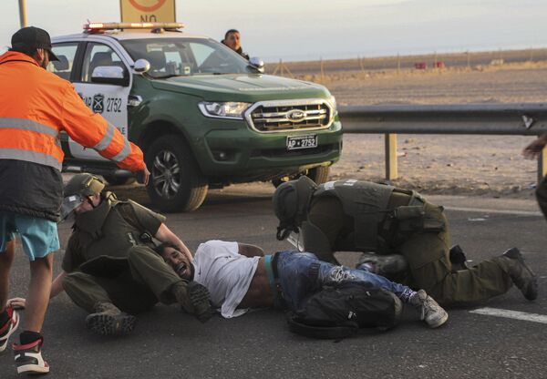 Мигрант задержан чилийской полицией, когда он заблокировал шоссе на границе Чили и Перу, недалеко от Арики, Чили, во вторник, 2 мая 2023 года. - Sputnik Молдова