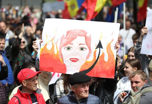 Участники акции протеста оппозиции в Кишиневе. держат в руках рукотворный плакат, на котором изображен портрет президента страны Майи Санду. - Sputnik Молдова