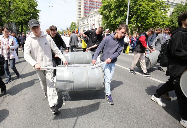 Молодые участники антиправительственного протеста в Кишиневе несут пустые металлические канистры, которые используют как барабаны для создания шума. - Sputnik Молдова