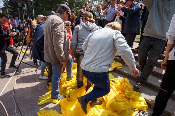 Участники антиправительственного митинга в Кишиневе топчут флаги с партийной символикой правящей в стране партии PAS. - Sputnik Молдова