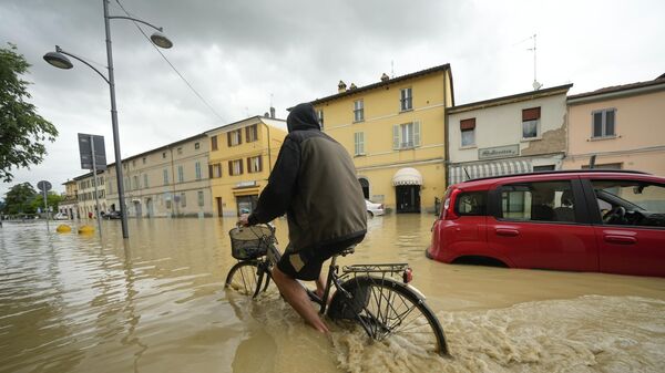 Велосипедист едет по затопленной улице в деревне Кастель-Болоньезе, Италия - Sputnik Молдова