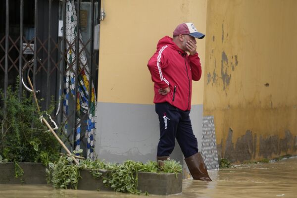 Мужчина наблюдает за затопленной улицей в деревне Кастель-Болоньезе, Италия. - Sputnik Молдова