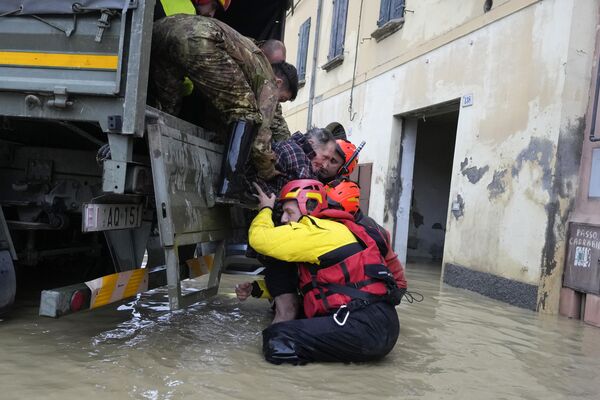 Пожарные спасают пожилого мужчину в затопленной деревне Кастель-Болоньезе, Италия. - Sputnik Молдова
