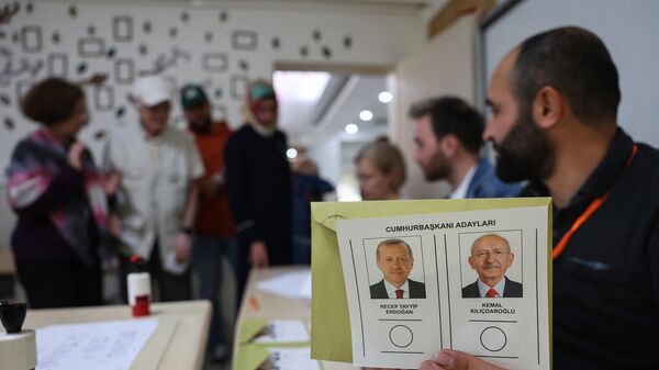 Un oficial electoral arată un buletin de vot care îi înfățișează pe cei doi candidați, Recep Tayyip Erdogan (S) și Kemal Kilicdaroglu la o secție de votare din Ankara. - Sputnik Moldova