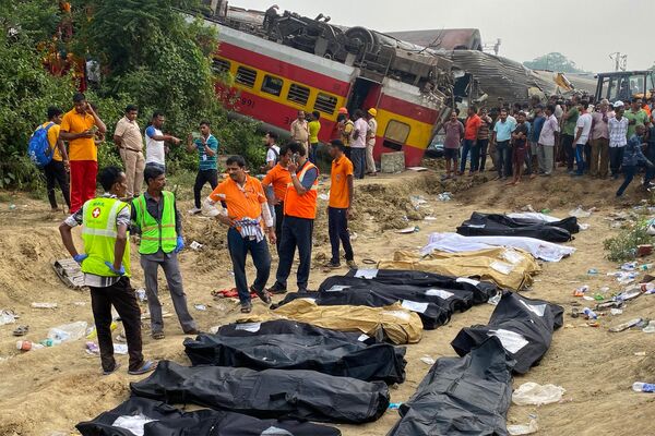 Спасатели рядом с телами погибших при столкновении поездов в Индии. - Sputnik Молдова