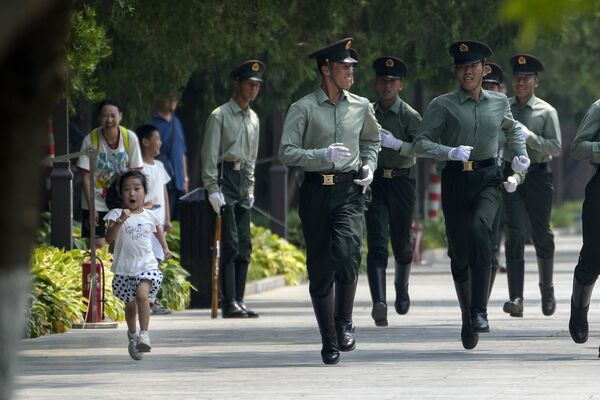 Девочка бежит вместе с членами почетного караула, когда они отрабатывают марш в Пекине, Китай. - Sputnik Молдова