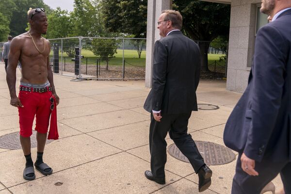 Министр обороны Германии Борис Писториус проходит мимо мужчины с голым торсом в Вашингтоне, США. - Sputnik Молдова
