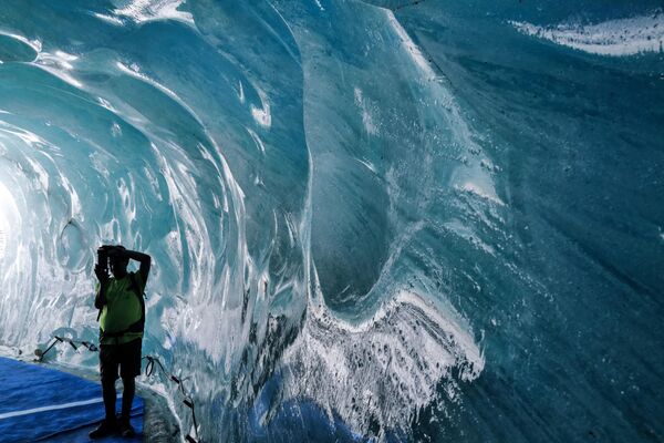 Un turist face fotografii în interiorul Grotte de Glace (Peștera de Gheață) din Mer de Glace (Marea de Gheață) din Chamonix-Mont-Blanc, în Alpii francezi, la 11 iulie 2023. - Sputnik Moldova