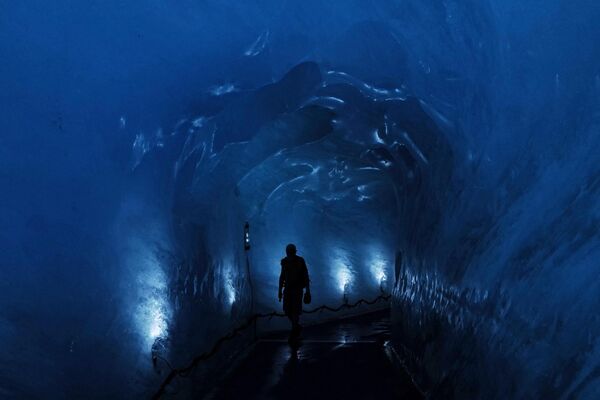 O persoană se plimbă în interiorul Grotte de Glace (Peștera de Gheață) din Mer de Glace (Marea de Gheață) din Chamonix-Mont-Blanc, în Alpii francezi, la 11 iulie 2023. - Sputnik Moldova