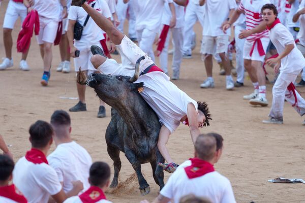 Un participant este răsturnat de un taur în timpul  sărbătoarei (alergarea taurilor) din cadrul festivalului San Fermin din Pamplona, nordul Spaniei, pe 8 iulie 2023. Mii de oameni participă în fiecare an la festivalul care durează o săptămână în timpul faimoaselor „encierro&quot; - Sputnik Moldova