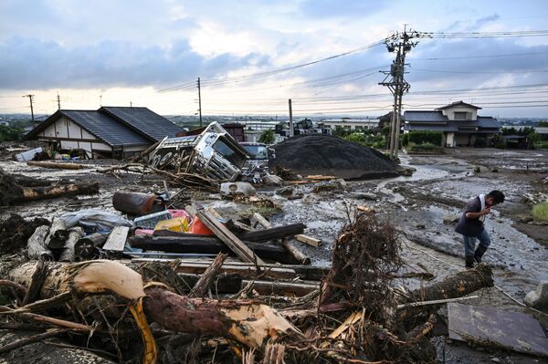 Un bărbat trece pe lângă ruine provocate de inundații pe un drum din orașul Kurume, prefectura Fukuoka, după ce ploile abundente au afectat zone extinse din insula Kyushu. O persoană a fost ucisă, iar sute de mii de oameni au fost îndemnați să își evacueze locuințele în sud-vestul Japoniei, după ce meteorologii au avertizat că vor fi &quot;cele mai puternice ploi din istorie&quot; în  această regiune. - Sputnik Moldova