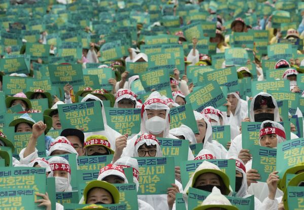 Membri ai Sindicatului coreean al lucrătorilor din domeniul sănătății își țin pancartele în timpul unui miting organizat împotriva politicii de muncă a guvernului de la Seul.  Coreea de Sud, joi, 13 iulie 2023. - Sputnik Moldova