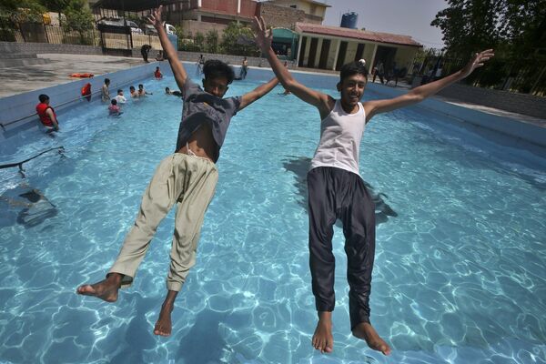 Спасение от жары – молодые люди прыгают в бассейн в Пакистане. - Sputnik Молдова
