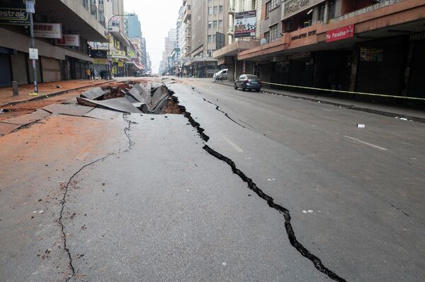Провал, образовавшийся на проезжей части в результате подземного взрыва в деловом квартале Йоханнесбурга, ЮАР. - Sputnik Молдова
