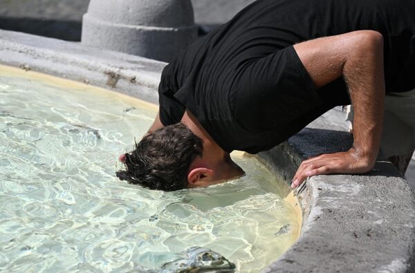 Мужчина, чтобы охладиться, ныряет головой в воду фонтана на площади Пьяцца дель Пополо в Риме. - Sputnik Молдова