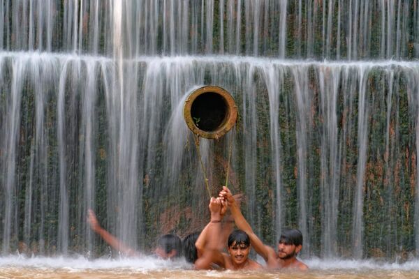 Молодые пакистанцы ищут прохладу в водопаде, в то время как температура воздуха достигла 36 градусов по Цельсию. - Sputnik Молдова