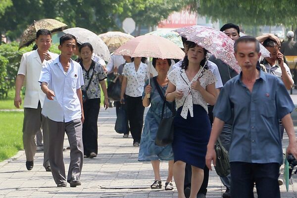Прохожие во время жаркого дня в Пхеньяне, Северная Корея. - Sputnik Молдова
