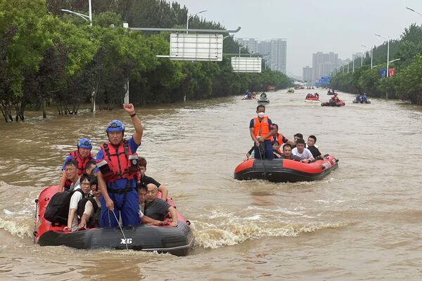 Жители эвакуируются на резиновых лодках через паводковые воды в Чжуочжоу в провинции Хэбэй на севере Китая. - Sputnik Молдова
