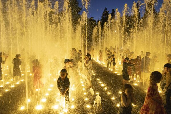 Дети спасаются от летней жары в фонтане в Иерусалиме. - Sputnik Молдова