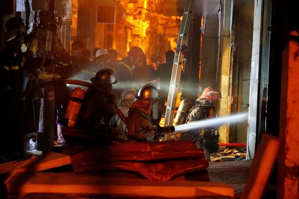 Пожарные тушат пожар и спасают людей в многоквартирном доме в Ханое. - Sputnik Молдова