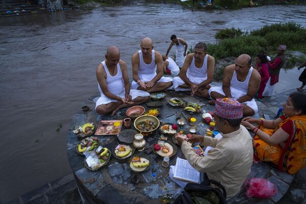 Непальские индуисты совершают ритуалы в честь своих умерших отцов на берегу реки Багмати во время  праздника &quot;Кусе Аунси&quot; в храме Гокарнешвор, Катманду, Непал. - Sputnik Молдова