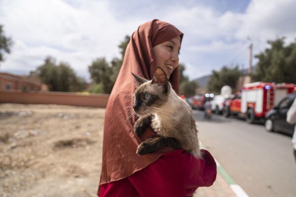 Женщина держит на руках кошку, которую она спасла после землетрясения, Марокко. - Sputnik Молдова