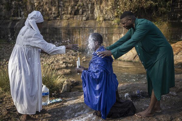 Женщина выливает молоко на голову другого верующего во время ритуала очищения, ЮАР. - Sputnik Молдова