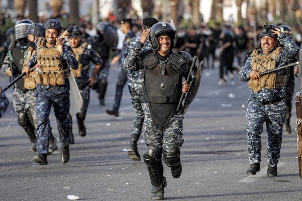 Полицейские по борьбе с беспорядками разгоняют протестующих, собравшихся на площади Тахрир в Багдаде, Ирак. - Sputnik Молдова