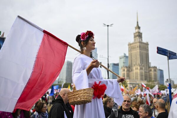 Женщина с польским флагом участвует в марше в поддержку оппозиции против правящей популистской партии &quot;Право и справедливость&quot; в Варшаве, Польша. - Sputnik Молдова