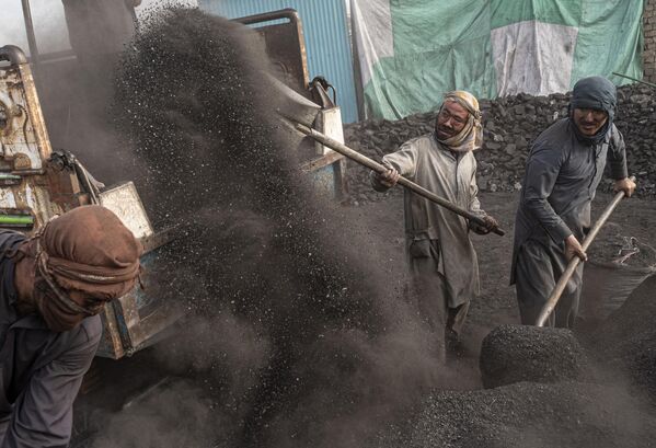 Рабочие сгребают уголь в грузовик на угольном складе на окраине Кабула. - Sputnik Молдова