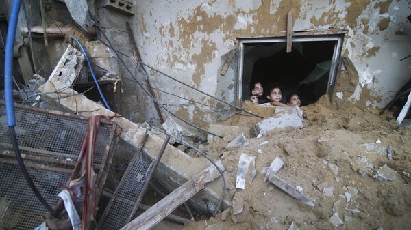 Палестинские дети выглядывают из-под руин разрушенного здания в результате израильских авиаударов в Рафахе, сектор Газа - Sputnik Moldova