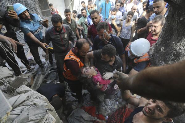 Палестинцы спасают ребенка из-под завалов после израильских авиаударов по городу Газа, сектор Газа, среда, 18 октября 2023 года. - Sputnik Молдова