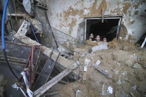 Палестинские дети смотрят на дом семьи Занон, разрушенный в результате израильских авиаударов в Рафахе, сектор Газа, суббота, 14 октября 2023 года. - Sputnik Молдова