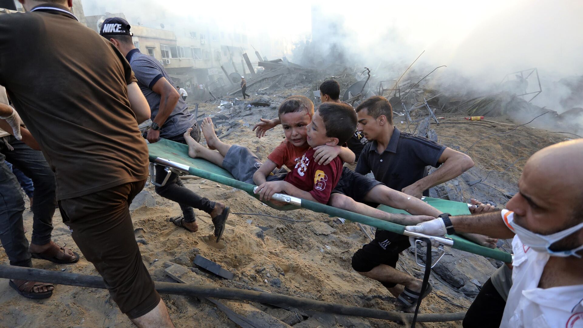 Палестинцы эвакуируют двух раненых мальчиков из разрушенного в результате израильских авиаударов по городу Газа - Sputnik Moldova, 1920, 19.11.2023