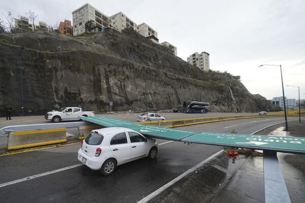 Дорожный знак лежит на автомобиле после урагана &quot;Отис&quot;, пронесшегося над Акапулько, Мексика, среда, 25 октября 2023 года. - Sputnik Молдова