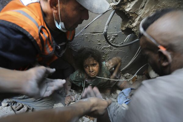 Палестинцы пытаются вытащить девочку из-под обломков здания, разрушенного в результате израильских авиаударов, в лагере беженцев Джабалия, север сектора Газа - Sputnik Молдова