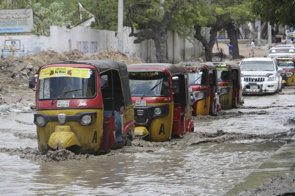 Туктуки проезжают по затопленной дороге после сильного дождя в Могадишо, Сомали, понедельник, 13 ноября 2023 года. - Sputnik Молдова