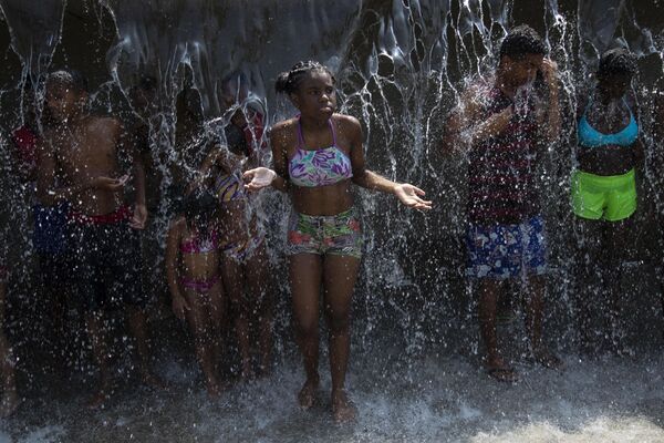 Люди охлаждаются в фонтане в парке Мадурейра во время жары в Рио-де-Жанейро, Бразилия, среда, 15 ноября 2023 года. - Sputnik Молдова