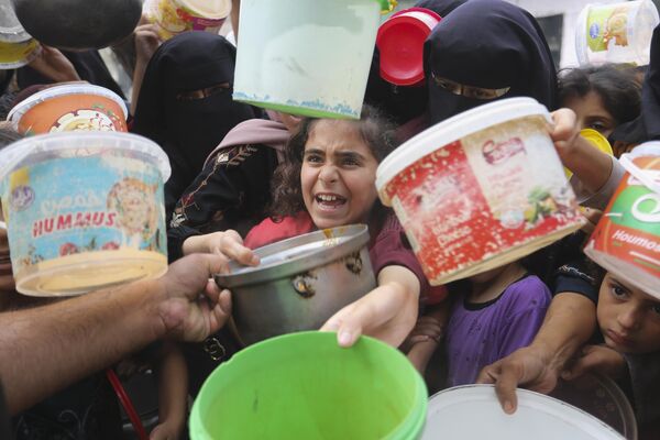 Палестинцы выстраиваются в очередь за едой во время продолжающейся израильской бомбардировки сектора Газа в Рафахе в понедельник, 13 ноября 2023 года. - Sputnik Молдова